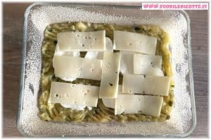 Versiamo metà dell'impasto nella pirofila, aggiungiamo la mozzarella a fette e la provola