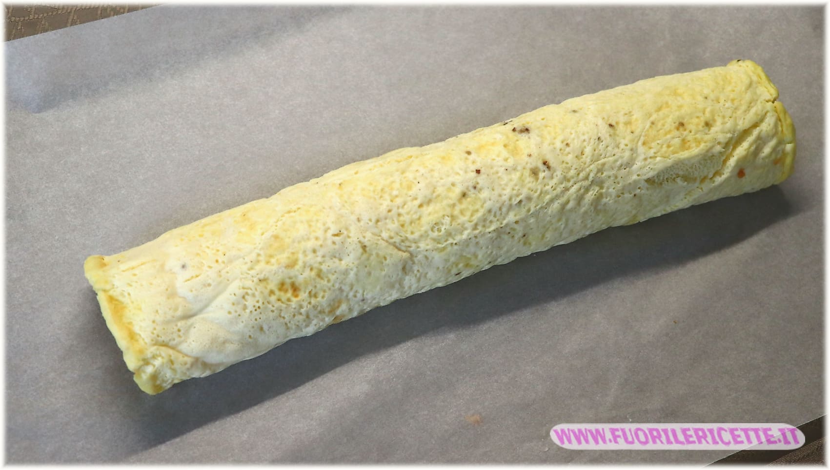Avvolgere il rotolo di frittata nella stessa carta forno
